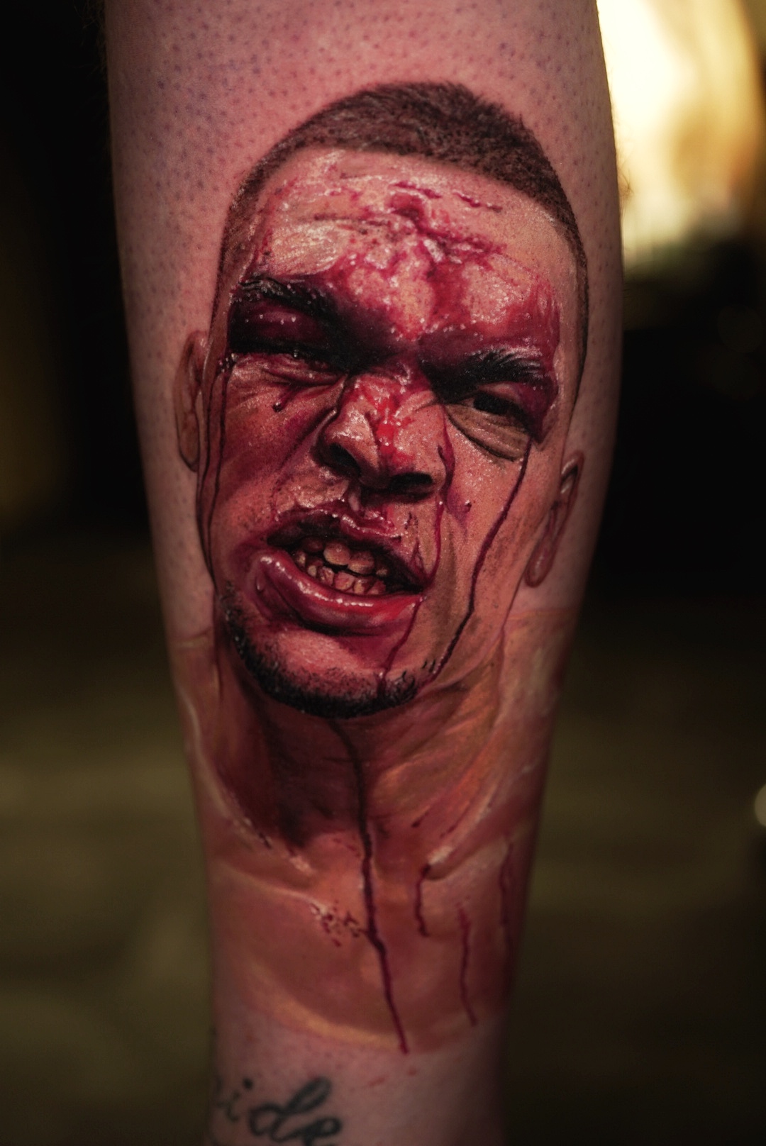 Color realism tattoo of a bruised face with red tones on a lower leg